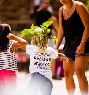 two young girls walking down a street with a woman