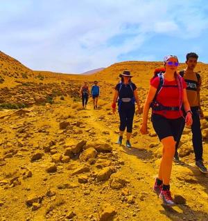 a group of people walking on a dirt trail
