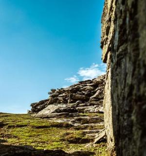 a stone wall on a hill with a blue sky