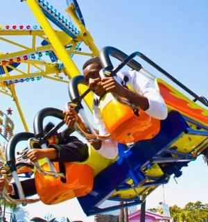 two people riding on a roller coaster at a carnival