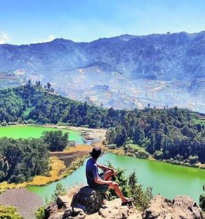 a person sitting on an elephant overlooking a river