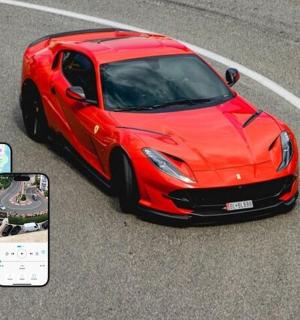 červené auto jedoucí po silnici s mobilním telefonem