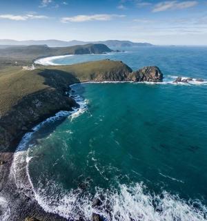 an aerial view of the ocean and a rocky coast