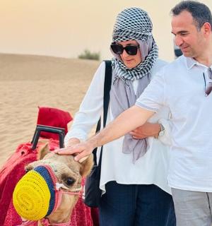 一名男子和一名女子带着一只狗站在沙漠中