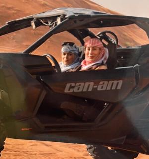 two people sitting in a atv in the desert