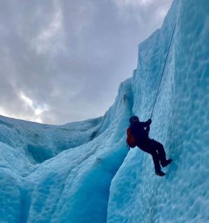 a person is climbing on an ice iceberg