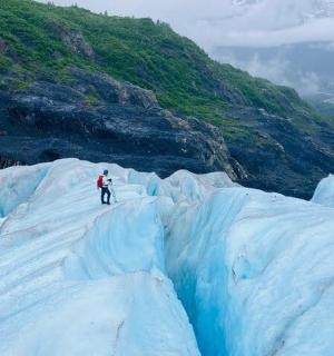 osoba stojící na vrcholu ledovce