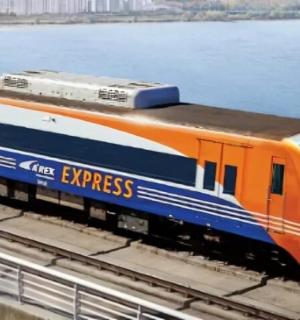 an orange and blue train on the tracks near the water