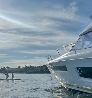 two people standing in the water next to a boat