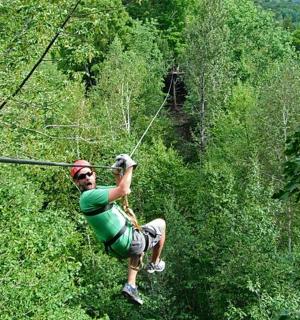 a man on a zip line in the trees