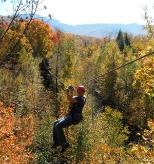 a woman on a zip line in the forest
