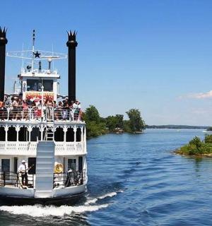 a ferry boat on a river with people on it