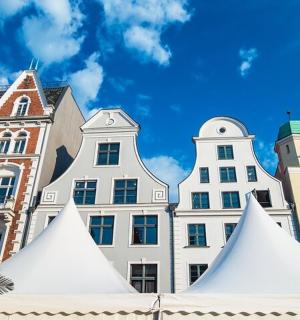 a group of white tents in front of buildings