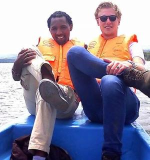 two men are sitting on a boat on the water