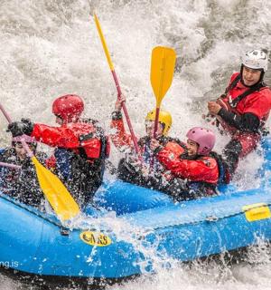 一群人坐在河里的木筏上