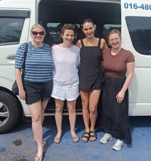 um grupo de pessoas em pé na frente de uma van