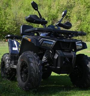 Černá čtyřkolka zaparkovaná v trávě na poli