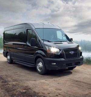 a black van driving on a dirt road