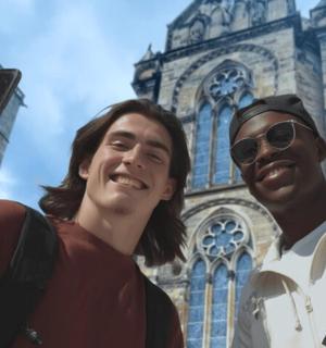 a man and a woman taking a picture in front of a building