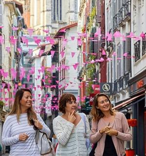 drei Frauen gehen eine Straße in einer Stadt entlang
