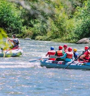 eine Gruppe von Menschen raftet auf einem Fluss