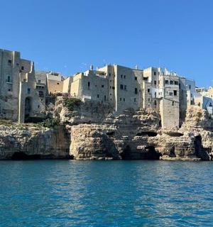 a group of buildings on top of a rocky island in the water