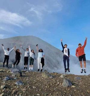 a group of people jumping on top of a mountain