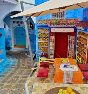 一座蓝色的建筑,里面有一张桌子和一把雨伞