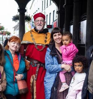 一群人站在一个穿着戏服的男人旁边