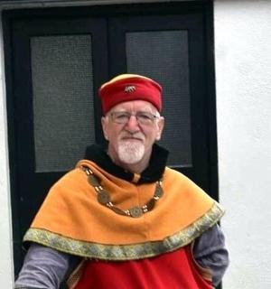 starší muž oblečený jako kněz stojící před dveřmi