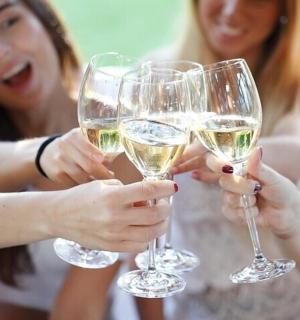 a group of women holding up wine glasses