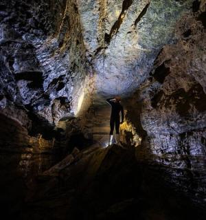 muž stojí v temné jeskyni