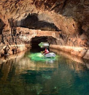a person in a boat in a cave in the water