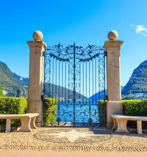 a gate in a garden with mountains in the background