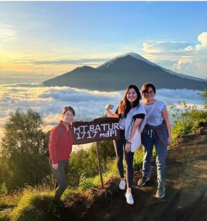 กลุ่มคนยืนอยู่ข้างป้ายบนภูเขา