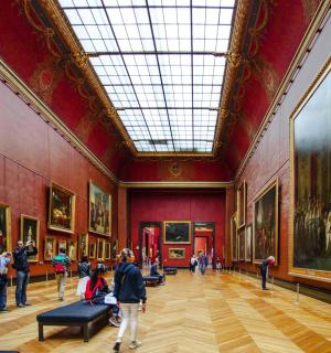 people standing in an art gallery with paintings on the walls