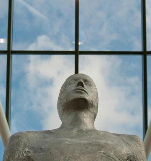 a statue of a man looking up at the sky