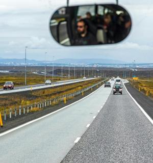 a rear view mirror of a car driving down a highway