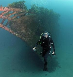 Muž v neoprenovém obleku stojí ve vodě
