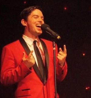 一位西装革履的男士对着麦克风讲话