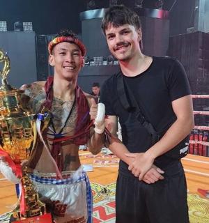 two men are standing next to a trophy