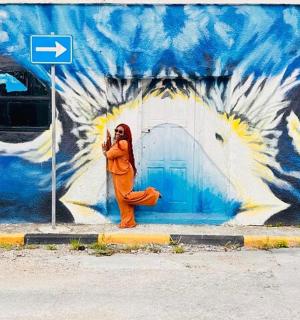 一名女子在壁画前打电话