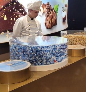 ένας σεφ που στέκεται μπροστά σε μια βιτρίνα φαγητού