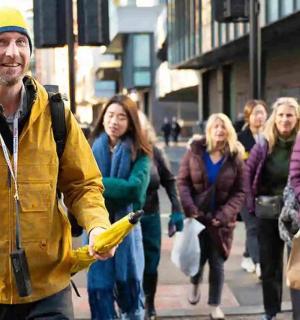 Ein Mann geht mit einer Gruppe von Menschen eine Straße entlang