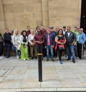 en gruppe mennesker, der står foran en bygning