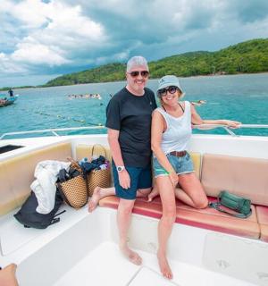 a man and woman sitting on the back of a boat