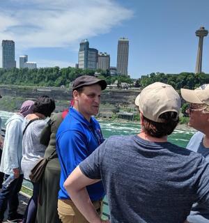 a group of people standing next to a river