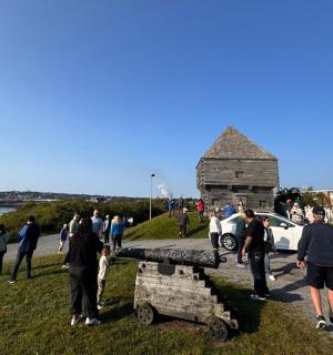 一群人站在路上的一辆车周围