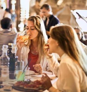 two women sitting at a table eating food