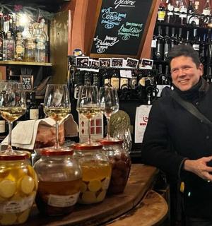 muž stojící za barem se sklenicemi vína